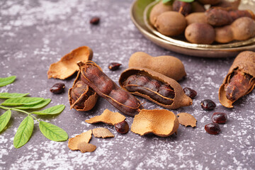 Tasty tamarinds and seeds on grey background