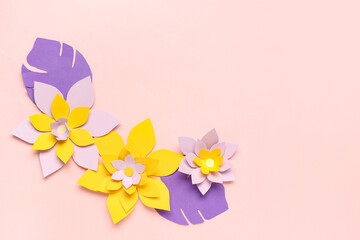 Colorful origami flowers with leaves on pink background