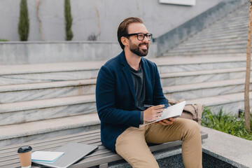 handsome busy bearded man working in park