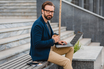 handsome busy bearded man working in park