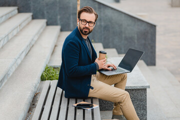 handsome busy bearded man working in park