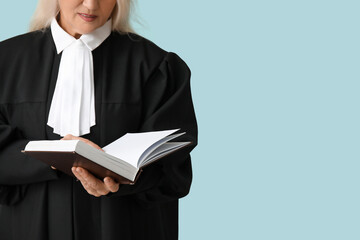 Female judge with book on blue background
