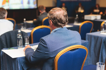 Audience at the modern conference hall listens to lecturer, people on a congress together listen to...