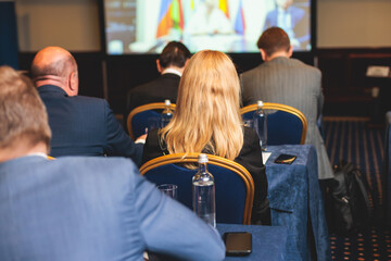 Audience at the modern conference hall listens to lecturer, people on a congress together listen to...