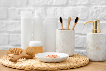Different bath supplies near white brick wall in bathroom