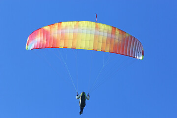 Paraglider flying in a blue sky