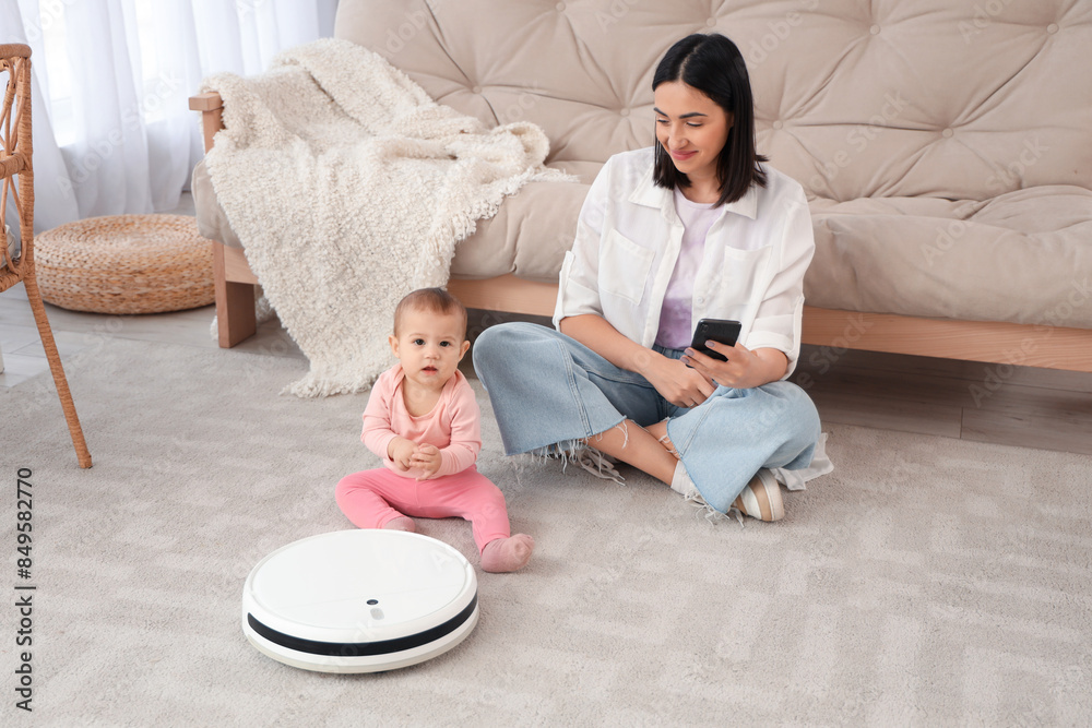 Sticker Cute little baby with robot vacuum cleaner and mother on carpet at home