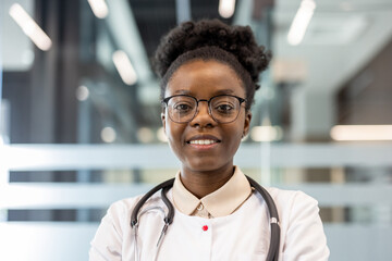 Portrait of a confident female doctor in a modern hospital setting, smiling at the camera....