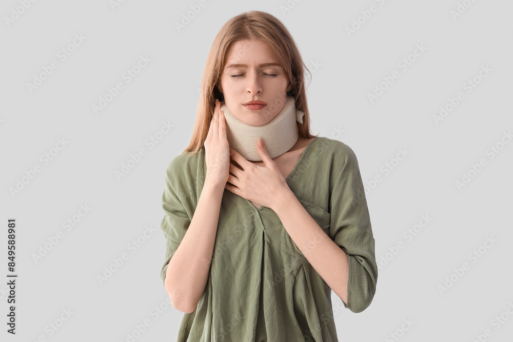 Canvas Prints Injured young woman with cervical collar after accident on light background