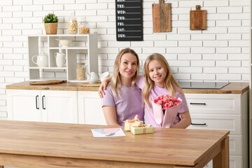 Cute little girl with her mom, gifts and bouquet for Mother's Day at home