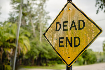 Close-up DEAD END, diamond yellow and black old rustic sign