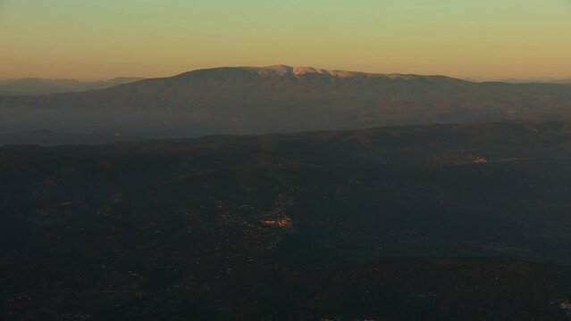 vue a&eacute;rienne du Mont Ventoux au couch&eacute; du soleil avec un village perch&eacute; du Luberon &eacute;clair&eacute; par les derniers rayons du soleil