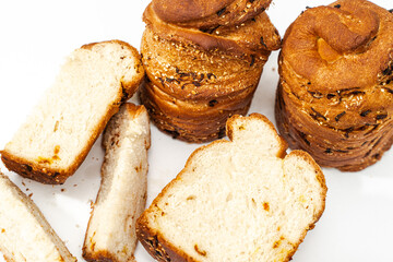 Homemade Easter cakes with raisins. Whole brioche and cut into pieces on a white table.