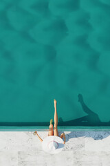 Young girl with in bikini and glass of champagne sunbathing by swimming pool. Summer swimming pool party. 3d render. Top view