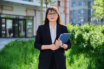 Fototapeta premium Portrait of business mature woman with digital tablet, outdoor