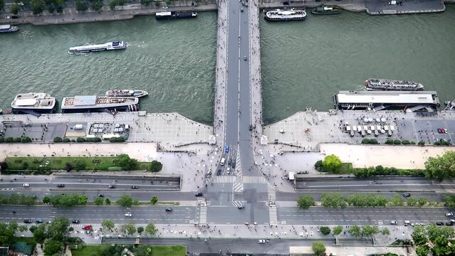 Many pedestrians and cars seen from above on Iena bridge over the river Seine in Paris, France.