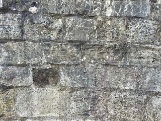 A close-up of a brick wall with varied shades of red and brown bricks.