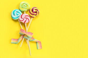 Bouquet made of sweet candies on yellow background