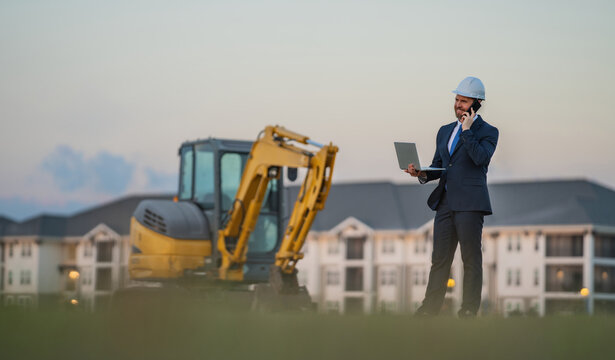 Worker in suit and helmet. Investor civil engineer, construction manager. Construction building developer at a construction site. Successful architect. Handsome hispanic builder man in suit.