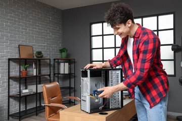 Obraz premium Male technician repairing PC unit in service center