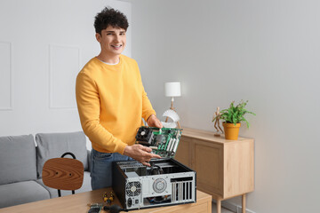 Young technician repairing computer unit at table in service center