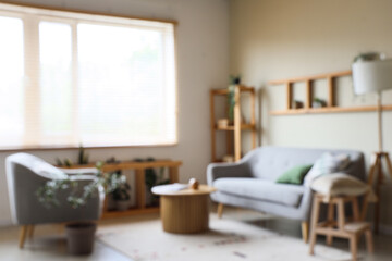 Interior of beautiful living room with grey sofa, shelving unit, coffee table and lamp