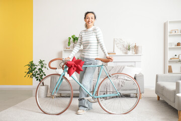 Fototapeta premium Mature woman with gift bicycle at home