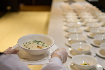The caterers carefully arranged white bowls in preparation for the event service