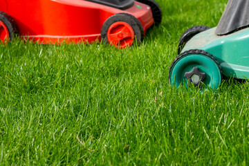 Seasonal maintenance works in garden, lawn movers in action, green grass cutting, lawn care, English lawn