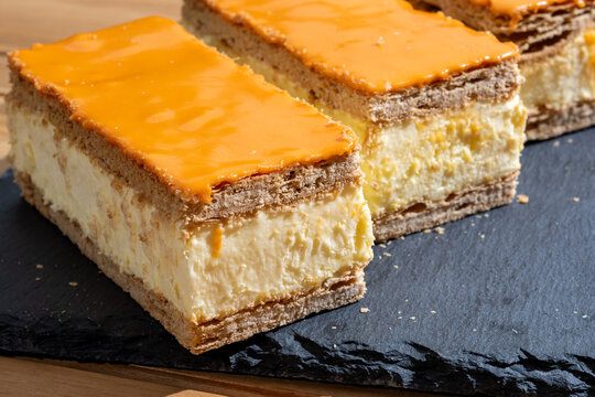 Celebration of the King birthday in Netherlands, tompoes or tompouce, iconic pastry in Netherlands made from puff dough, orange icing, cream