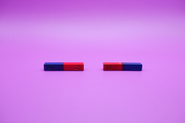 two bar magnets isolated on a purple background