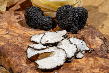 Cooking pasta with Italian black summer truffle, tasty aromatic mushroom, close up