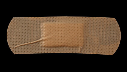 Adhesive band aid crumpled isolated on black background, top view