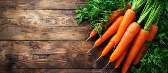 Carrots with green tops on wooden background