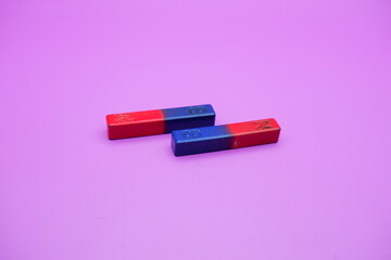 two bar magnets isolated on a purple background