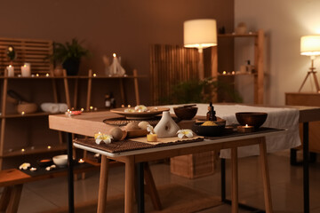 Spa composition with burning candles on table in dark salon
