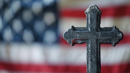 Close-up of a cross with an American flag in the background