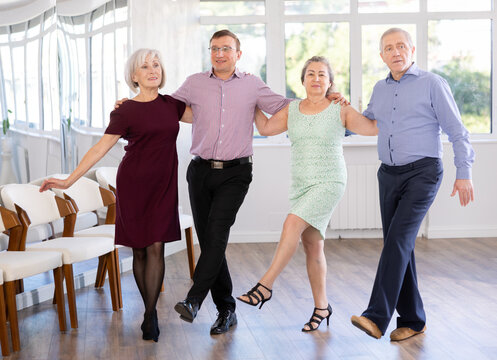 Elderly people with middle-aged man holding hands dancing hava nagila. Dance lessons for amateurs and beginners