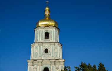 Obraz premium Bell tower of Saint Sophia Cathedral stands tall against a clear blue sky, features intricate architectural details, including golden dome and ornate designs. Kyiv, Ukraine