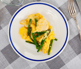 Diet and hearty breakfast is served on plate - omelette and chicken breast, complemented by...