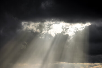 Sunlight beams breaking through clouds, symbolizing hope, clarity, and the triumph over darkness.