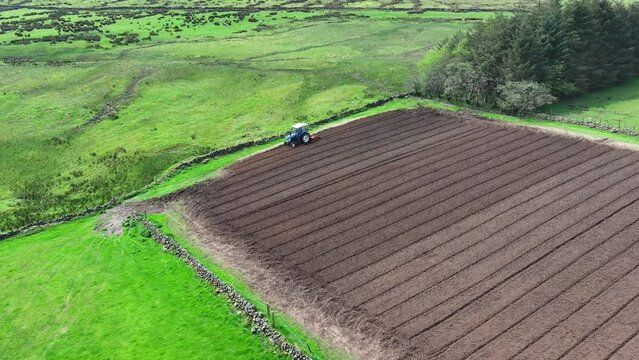 Aerial video of a Ford 6610 tractor rotovating a ploughed field for crops at Magill&rsquo;s farm Larne County Antrim Northern Ireland on 16-05-24