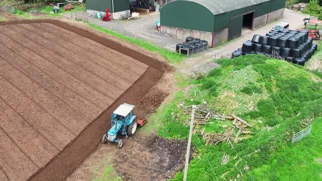 Aerial video of a Ford 6610 tractor rotovating a ploughed field for crops at Magill&rsquo;s farm Larne County Antrim Northern Ireland on 16-05-24