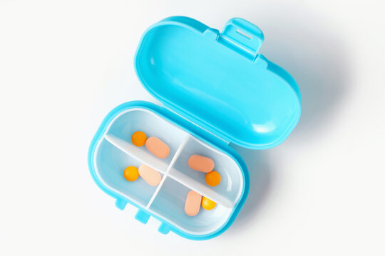 Plastic box pills close up on white background top view.