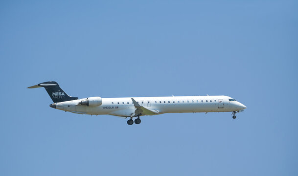 Mesa Airlines aircraft Bombardier CRJ-900 approaching the Dallas Fort Worth International Airport (DFW), blue skies.