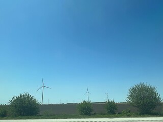 Panoramic view of wind farm or wind park, with high wind turbines for generation electricity with copy space. Green energy concept.