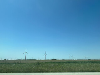 Panoramic view of wind farm or wind park, with high wind turbines for generation electricity with copy space. Green energy concept.