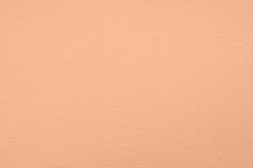 Peach fuzz color paper, closeup. Trendy shade of 2024 year
