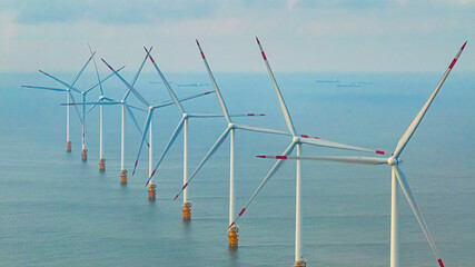 Windmill park with clouds and a blue sky, wind mill turbines in the ocean aerial view of a wind...