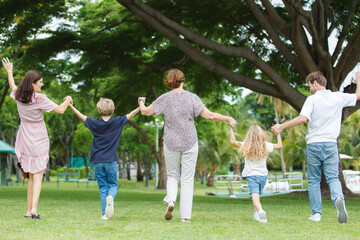 Caucasian family parent and their children picnic at the park in morning.